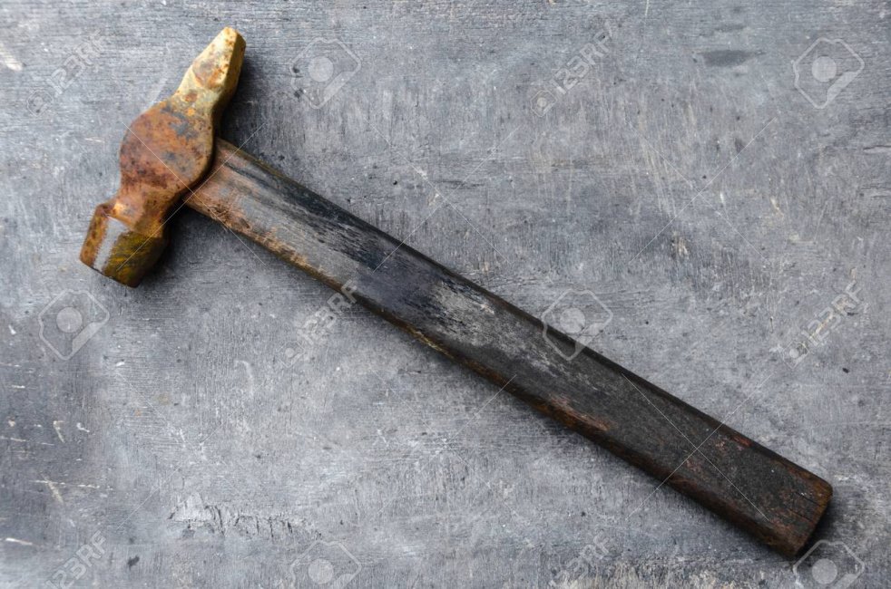 89417179-old-rusty-hammer-on-a-gray-wooden-background.jpg